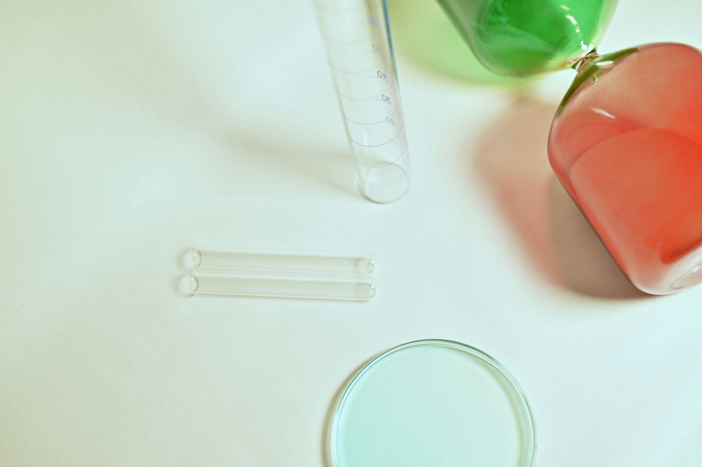 Verrerie de laboratoire aux teintes pastel sur fond clair