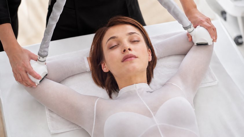 Femme en combinaison blanche recevant un soin par rouleaux motorisés, soin Icoone de Biostem