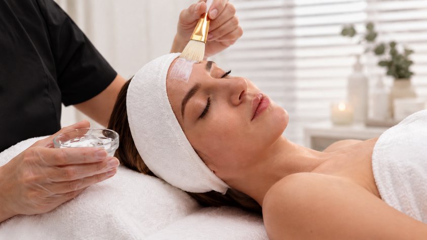 Masque appliqué au pinceau sur le visage d'une femme allongée, soin Physiodermie de Biostem