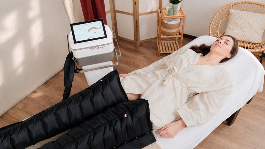 Femme allongée, jambes dans des bottes de pressothérapie, soin Pressothérapie de Biostem