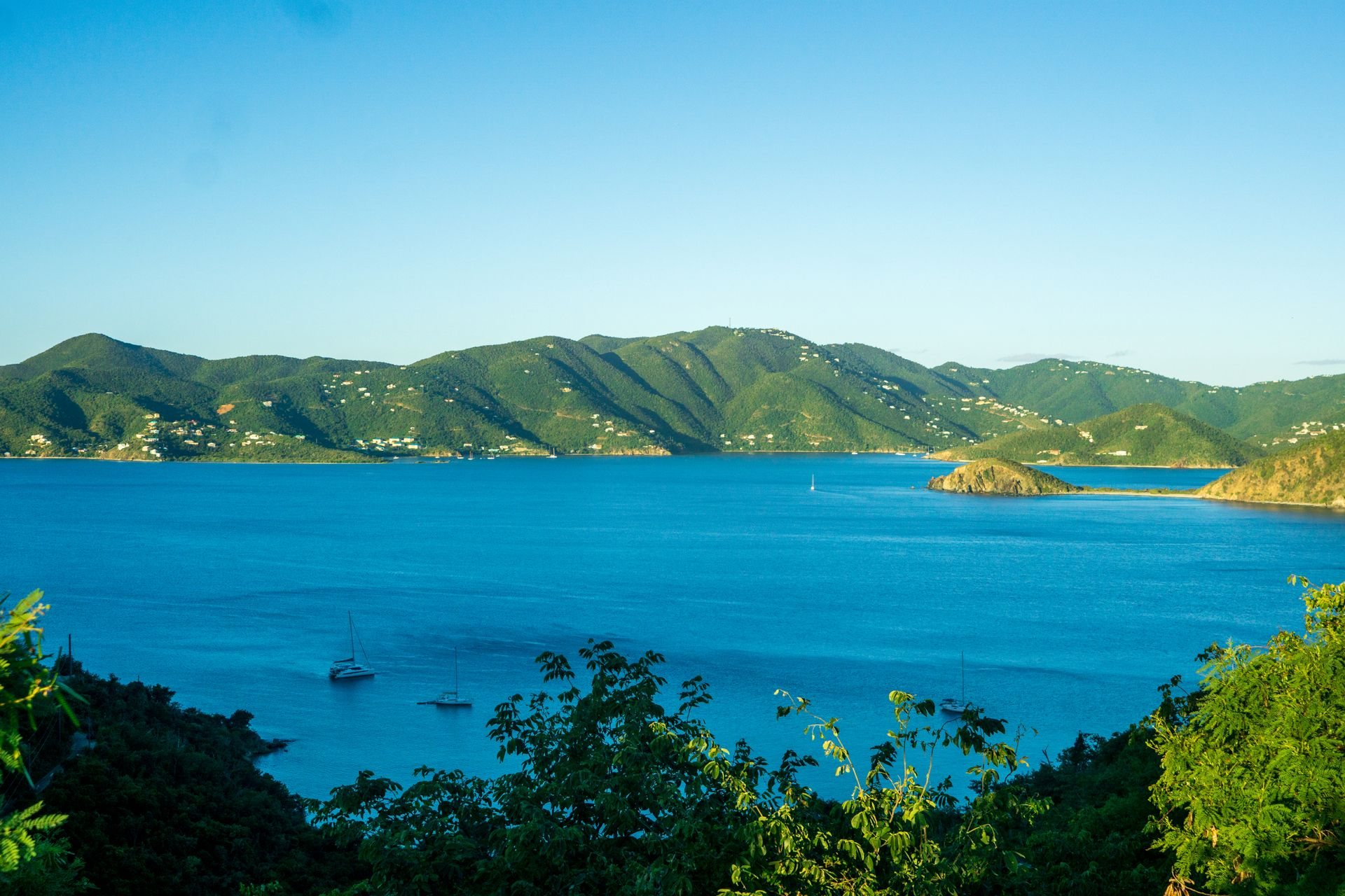 Baie des Caraïbes aux eaux turquoise, voiliers au mouillage devant des collines vertes