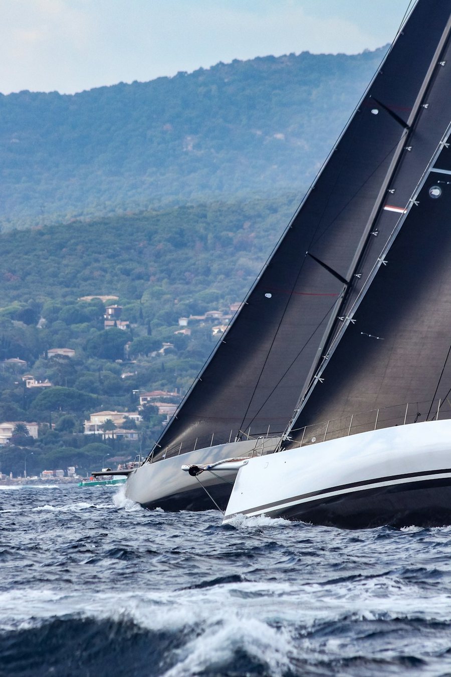 Voilier de course à la grand-voile noire, gîté au près
